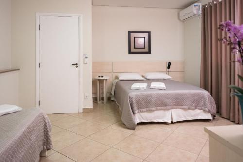 a bedroom with two beds with towels on them at Holambra Garden Hotel in Holambra