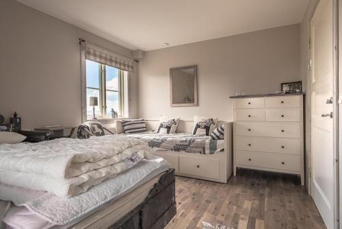 a bedroom with two beds and a dresser at Backlund Boende i Dalarna in Rättvik