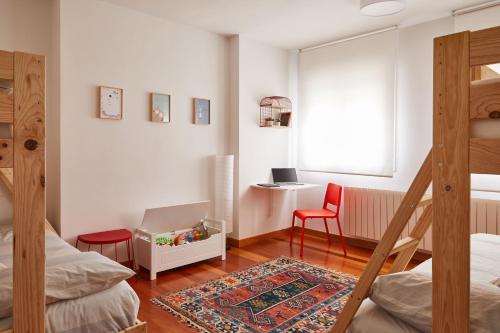 1 dormitorio con 2 camas, escritorio y silla en Urban Ezcaray en Ezcaray