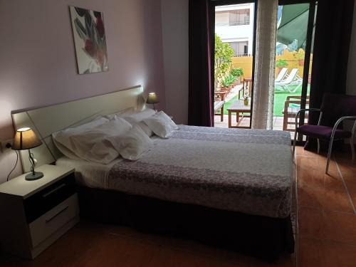 a bedroom with a bed and a view of a yard at 330 - Edf Aguamarina - Vacation Rental Home in the coast line of Golf del Sur in San Miguel de Abona