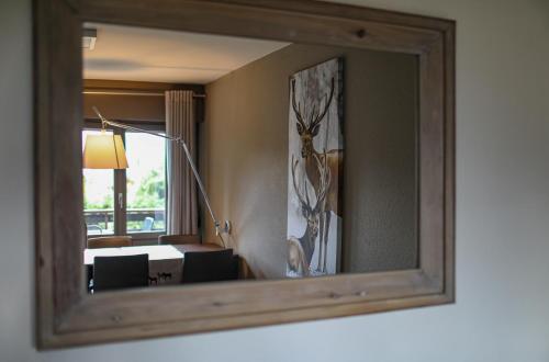 a mirror in a room with a dining room at My cozy escape in Crans-Montana