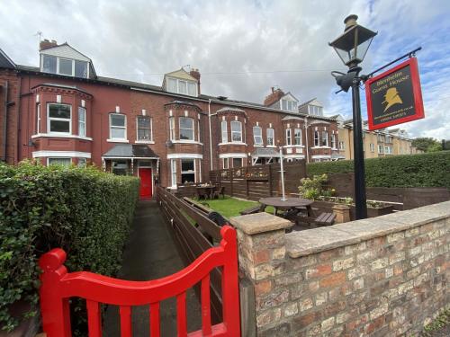 a red bench in front of a brick building at Blenheim Guest House in York