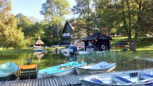 a group of boats on the water in front of a house at Ośrodek Wypoczynkowy Łańsk in Stawiguda