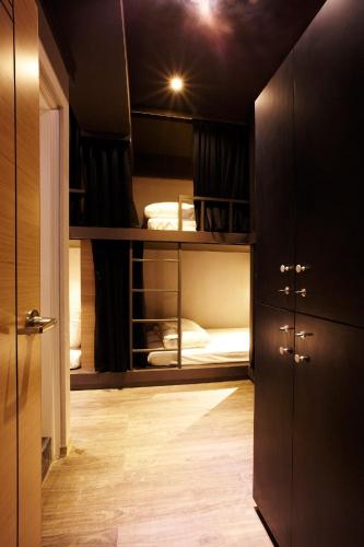 a small room with a bunk bed and a hallway at Main Inn Taipei in Taipei