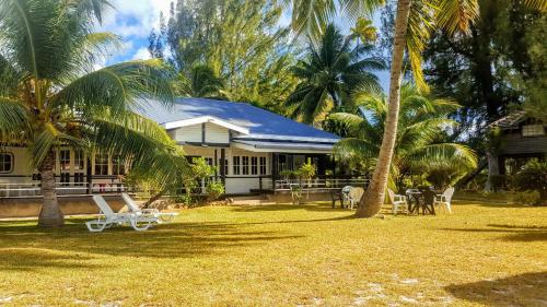 a house with palm trees in front of it at MOOREA - Villa Tereva Nui in Haapiti
