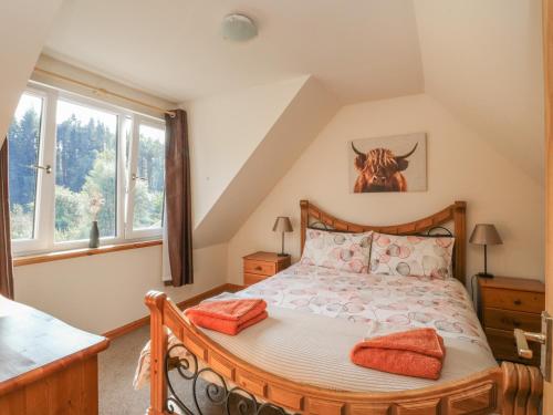 a bedroom with a large bed with orange pillows at Feagour in Ardverikie