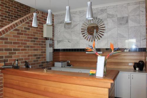 a kitchen with a counter and a brick wall at Heritage River Motor Inn in Grafton