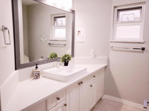 a bathroom with a white sink and a mirror at Yan lovely little house in Burnaby