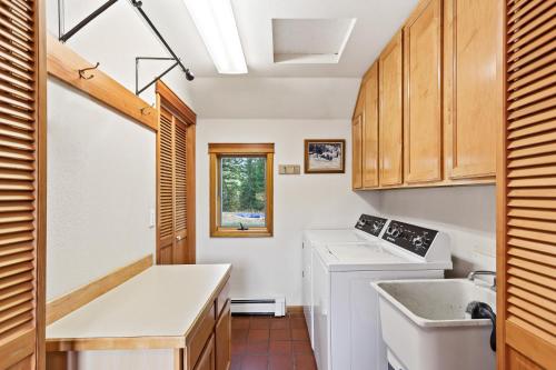 eine Küche mit Spüle, Waschmaschine und Trockner in der Unterkunft Lakeview Home with new hot tub - Sleeps 10 in Sandpoint