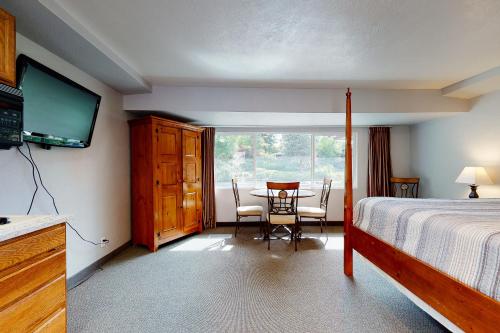 1 dormitorio con 1 cama y 1 mesa con sillas en Deschutes Riverside Escape en Bend