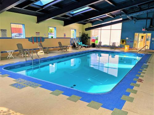 a swimming pool with a pool table and chairs at Days by Wyndham Niagara Falls Centre St. By the Falls in Niagara Falls