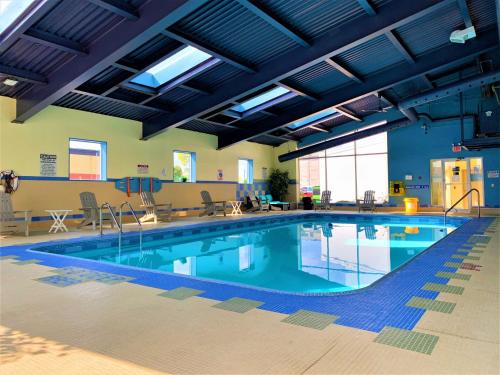 a large swimming pool with blue water in a building at Days Inn by Wyndham Niagara Falls Centre St By the Falls in Niagara Falls