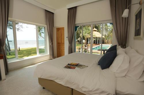 a bedroom with a bed with a view of the beach at Meet The Sea in Khlong Yai