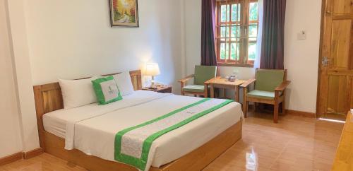 1 dormitorio con 1 cama, 2 sillas y mesa en Bamboo Resort Phu Quoc, en Phu Quoc
