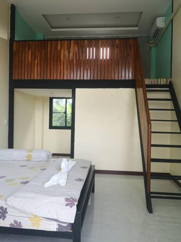a bedroom with two bunk beds and a staircase at BN Resort in Ban Nong Chum Saeng