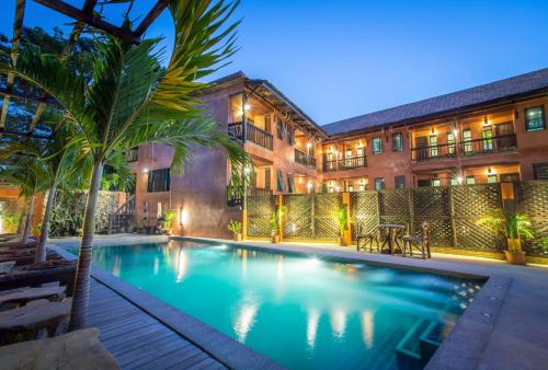 una piscina di fronte a un edificio di Rainforest ChiangMai Hotel a Chiang Mai