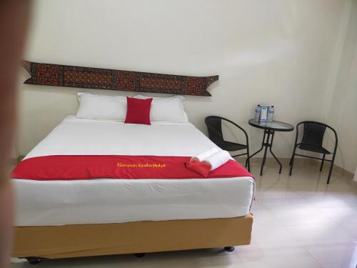 a bedroom with a bed with a red blanket at Gosyen Efata Toraja Hotel in Makale
