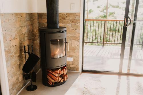a fireplace in a room with a stone wall at Rainforest Gardens - Luxury Hillside Accomodation with Views to Bay & Islands in Mount Cotton