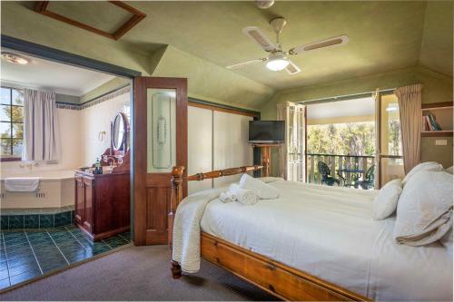 a bedroom with a bed and a window and a tub at Bimbadeen Mountain Retreat in Mount View