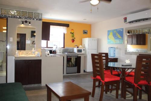 a kitchen and living room with a table and chairs at Cande's Apartments in Isla Mujeres