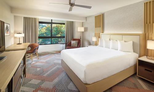 a hotel room with a large white bed and a desk at Hyatt Regency Monterey Hotel and Spa in Monterey