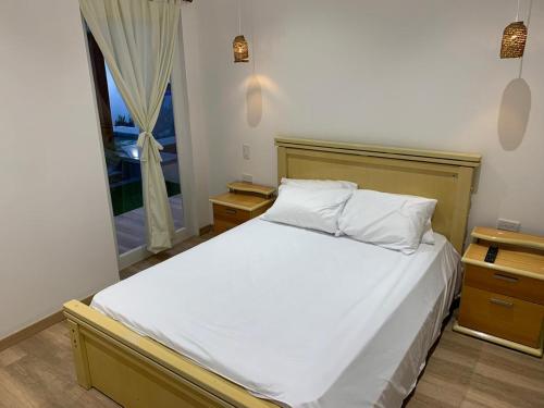 ein Schlafzimmer mit einem weißen Bett und einem Fenster in der Unterkunft Villa Gloria in Salinas
