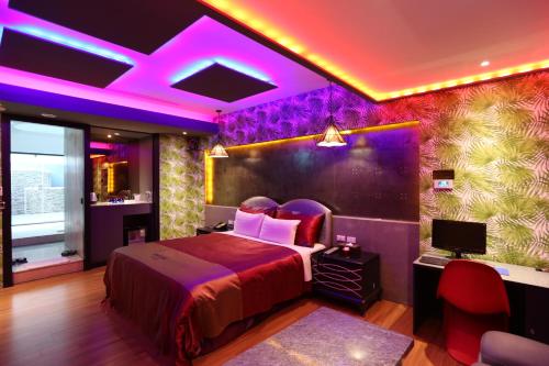 a bedroom with a bed with purple lights on it at Yosemite Motel - Chunghua Branch in Taichung