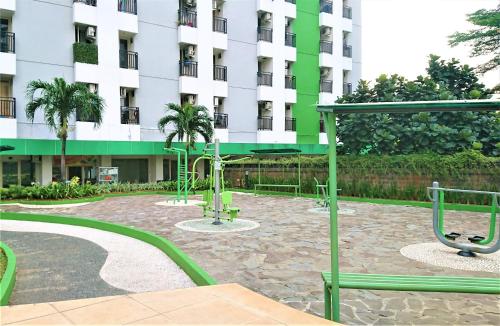 a building with palm trees in a courtyard at Apartment Green Lake View Ciputat by Celebrity Room in Pondokcabe Hilir