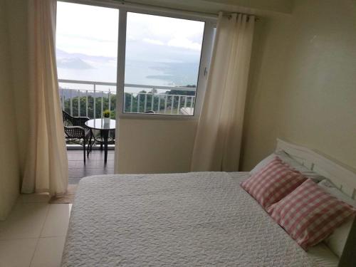 A bed or beds in a room at Bella Suites at Wind Residences Tagaytay