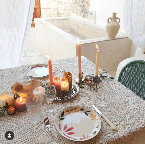 una mesa con velas y platos en House of Eleni, en Káthikas