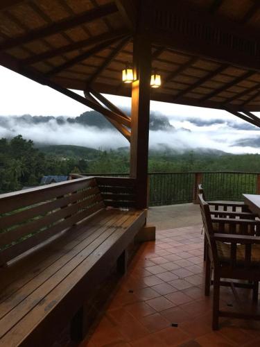 a porch with a bench and a view of the mountains at Billion Views Khaosok Homestay in Khao Sok