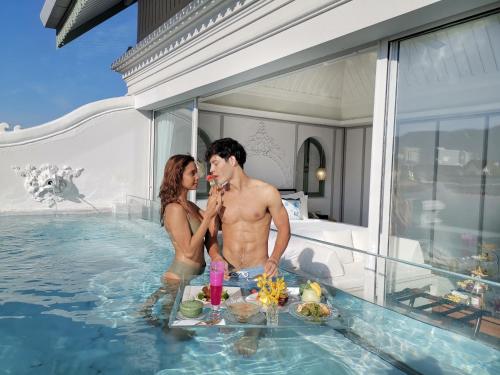 a man and a woman standing in a swimming pool at The Inside House in Chiang Mai