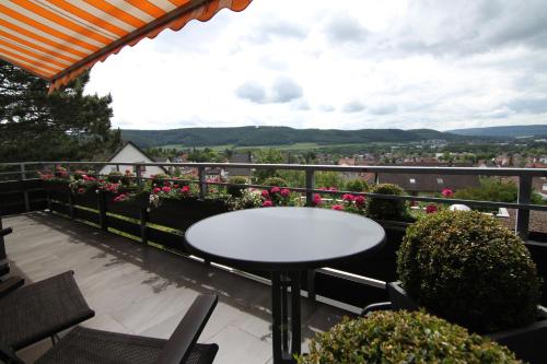 a table and chairs on a balcony with flowers at Ferienwohnung Kuck in Bad Pyrmont