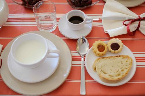 a table with plates of food and a cup of coffee at Agriturismo Arco di Sole in Alberobello