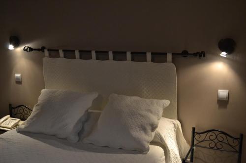 a bedroom with a bed with white sheets and pillows at Logis hotel Noemys Gradignan in Gradignan