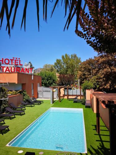 a swimming pool in the yard of a hotel apartment at Cévenol Hôtel in Millau