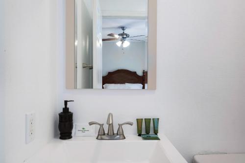 La salle de bains blanche est pourvue d'un lavabo et d'un miroir. dans l'établissement Los Angeles Retreat Close to Hotspots, à Los Angeles