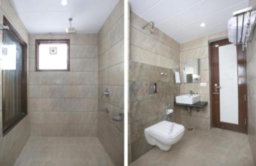 uma casa de banho com um chuveiro, um WC e um lavatório. em HOTEL SILVER PALM em Zirakpur