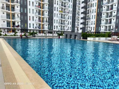 a large blue swimming pool in front of tall buildings at Afnan Homestay at Semenyih, Ascotte Boulevard in Semenyih