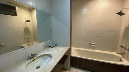 La salle de bains est pourvue d'un lavabo et d'une baignoire. dans l'établissement Whiz Capsule Hotel Grand Bromo, à Bromo