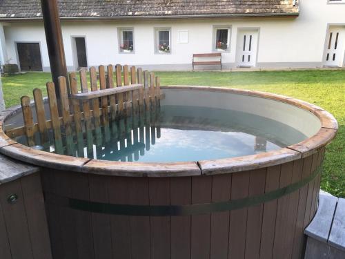 a circular pool with a wooden fence around it at Hűvösvölgy Vendégház in Lókút