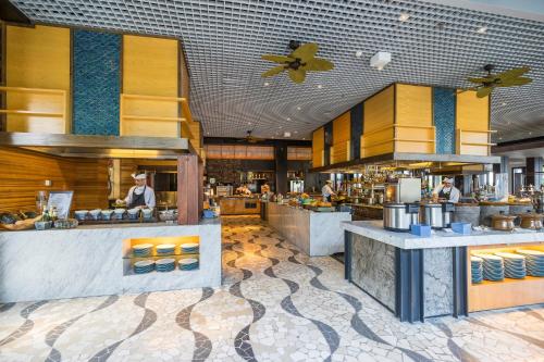 a restaurant with people preparing food in a kitchen at The Anvaya Beach Resort Bali in Kuta