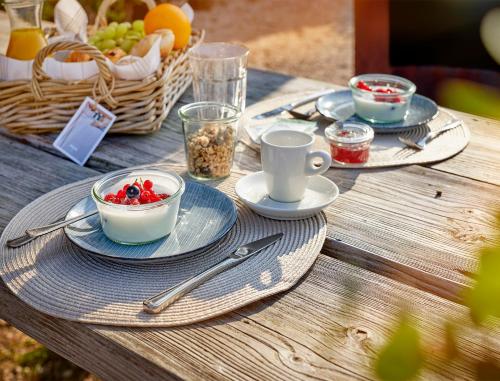 Hotel Zonne في نوردفايك أن زي: طاولة وصحون طعام وسلة فاكهة