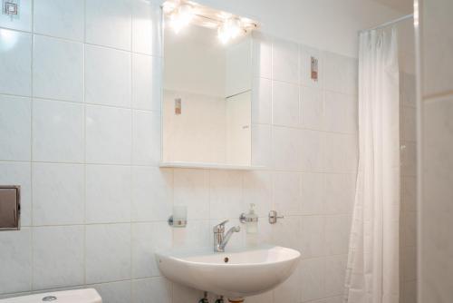 een witte badkamer met een wastafel en een douche bij Dobrý Kanec - Hostinec in Mělník