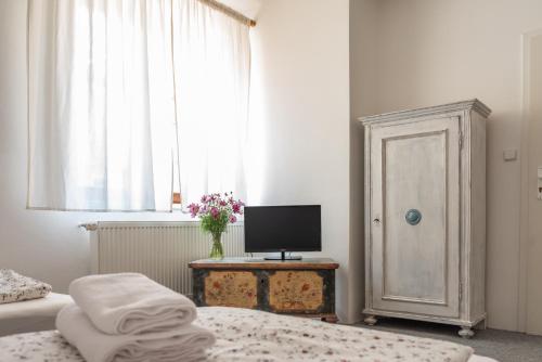 a bedroom with two beds and a television and a window at Dobrý Kanec - Hostinec in Mělník
