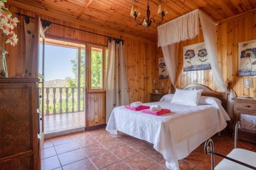 a bedroom with a bed and a large window at Casa las Olivas in Sayalonga