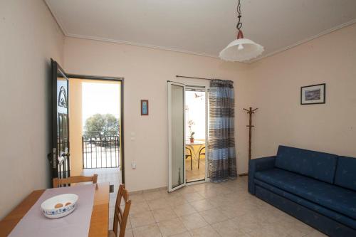 a living room with a blue couch and a table at Panagiota Apartments in Mavrovoúnion