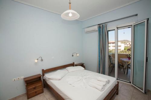 a bedroom with a bed and a balcony at Panagiota Apartments in Mavrovoúnion