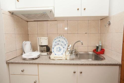 a kitchen counter with a sink and a mixer at Panagiota Apartments in Mavrovoúnion