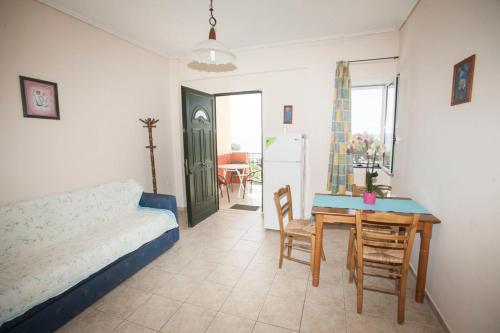a living room with a table and a bed and a kitchen at Panagiota Apartments in Mavrovoúnion